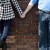 Engaged couple holding hands by brick wall