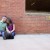 Engaged couple sitting by a brick wall